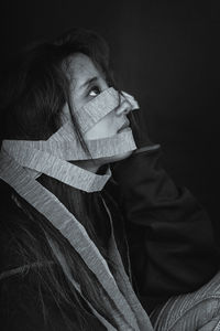 Close-up of woman with confetti against black background