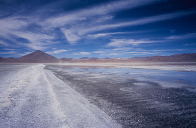 Scenic view of barren landscape against blue sky