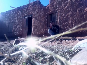 Man sitting against building