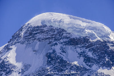 Scenic view of snowcapped mountains against clear blue sky