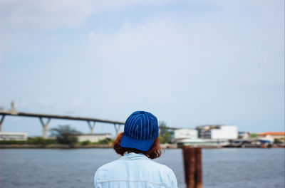 Rear view of woman against river against clear sky