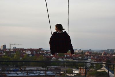 Woman on swing against sky