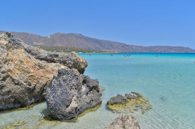 Scenic view of bay against clear blue sky