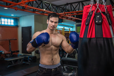 Portrait of shirtless punching in gym