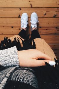 Low section of woman wearing warm clothing while standing on floorboard