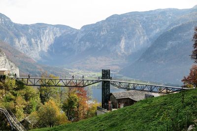 Bridge by mountains against sky