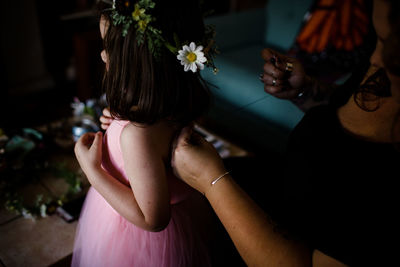 Aunt sewing back of dress to fit niece