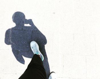 Low section of woman standing on shadow