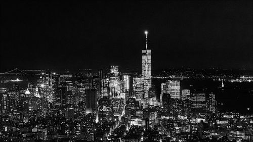 Illuminated modern buildings against sky at night