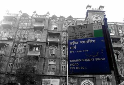 Low angle view of information sign against buildings in city