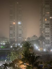 Illuminated buildings against sky at night