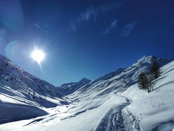 Scenic view of snow covered mountains against blue sky