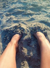 Low section of legs on sand at beach