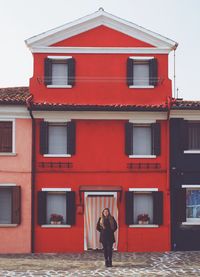 Full length of woman standing by building in city