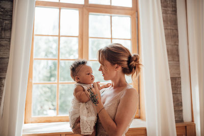 Mother and daughter standing on window