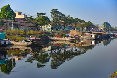 Scenic view of river by buildings against sky