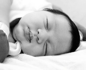 Close-up of baby sleeping on bed