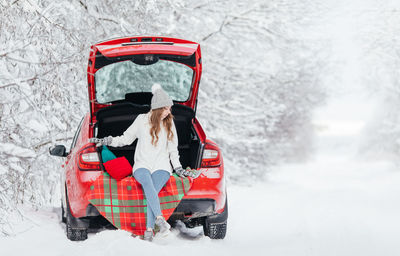 Rear view of man sitting in car during winter