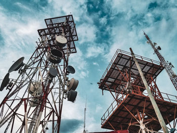 Low angle view of cranes against sky