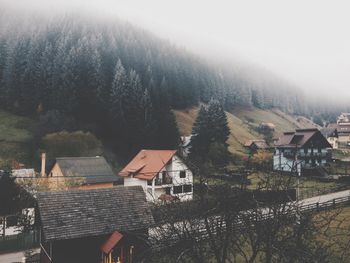 High angle view of houses by mountain during foggy weather