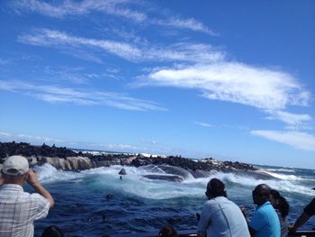 People enjoying at beach against sky