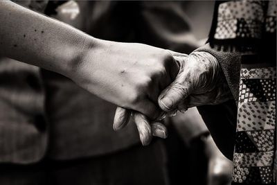 Cropped image of woman shaking hand with friend