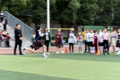 Group of people playing soccer on field