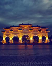 People in illuminated building at dusk