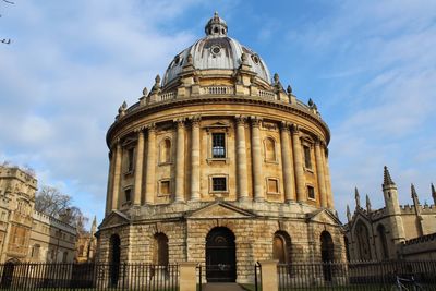 Low angle view of radcliffe camera against cloudy sky