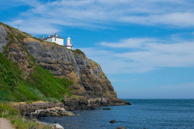 Rock formations by sea against sky