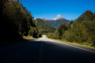 Road amidst trees against sky