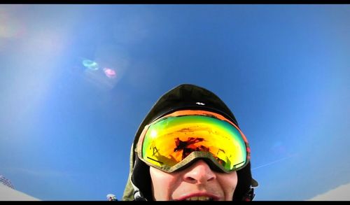 Low angle view of woman against clear blue sky