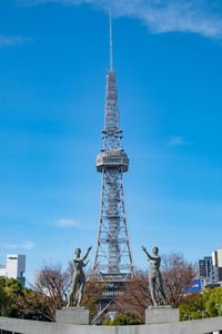 Communications tower in city against sky