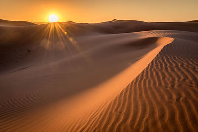 Scenic view of desert against sky during sunset