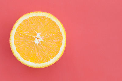 Close-up of orange slice against red background