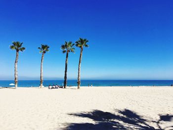 Scenic view of beach against clear blue sky