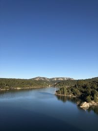 Scenic view of lake against clear blue sky