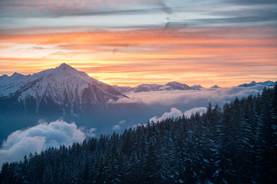 Scenic view of snowcapped mountains against sky during sunset