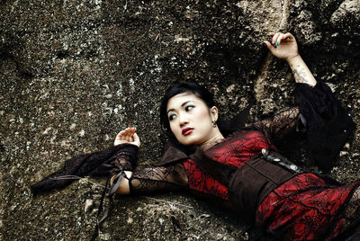 High angle view of young woman lying on field