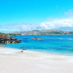 Scenic view of beach against blue sky