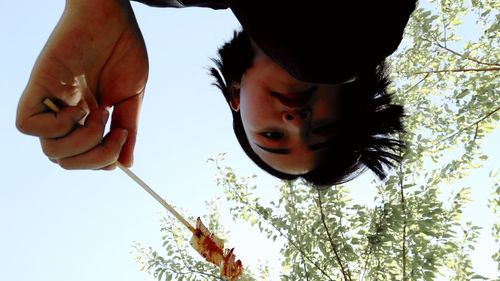 Directly below shot of teenage girl holding food against sky