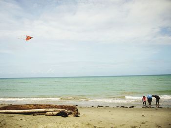 People on beach against sky