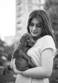 Rear view of girl holding dog