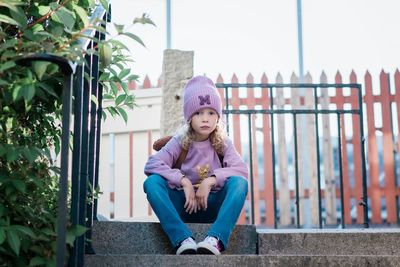 Young girl sitting on a step looking thoughtful waiting for school