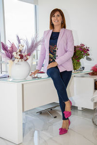 Portrait of a smiling young woman standing at home