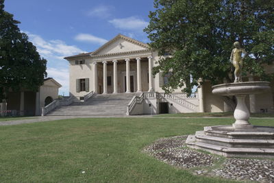 Statue in lawn against building