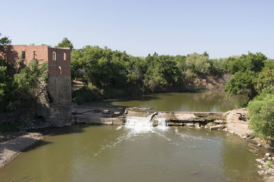 Scenic view of river by trees against sky