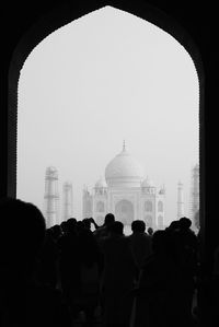 People in front of buildings against clear sky