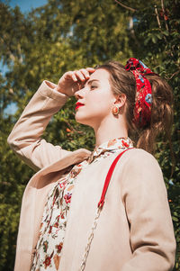 Close-up of young woman against tree