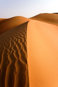 Sand dune in desert against clear sky